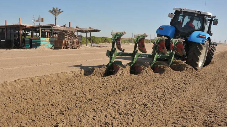 Un tractor llaura la platja del Prat el dimarts 28 de març al matí. 